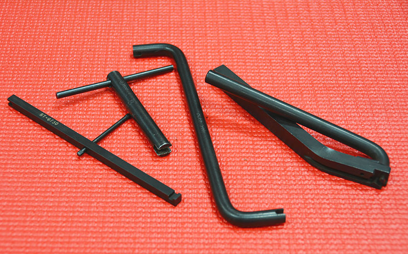 When the external choke pull-off made its appearance, so did the various external rods and connection parts. There are some pull-offs that use an internal screw or adjuster, located on the port end, usually a small slotted screw, or more commonly a socket head or Allen screw. Adjustment for most external choke breaks involves bending and twisting the connecting rods, and this can be trouble if you don’t invest in the tooling needed to bend without inducing lateral displacement. You don’t have to have the tooling; if you’re careful with a set of duck bill or stout needle nose pliers you can certainly bend the linkage into adjustment, but you only want to shorten or lengthen the linkage, you do not want to bend it inboard or outboard from its original operating plane because that will almost surely cause it to bind up as it moves through full travel. If you plan on doing a lot of carb work, look for these kinds of tools on eBay or other online sources. They are mostly obsolete and older techs are often selling off their vintage tools online.